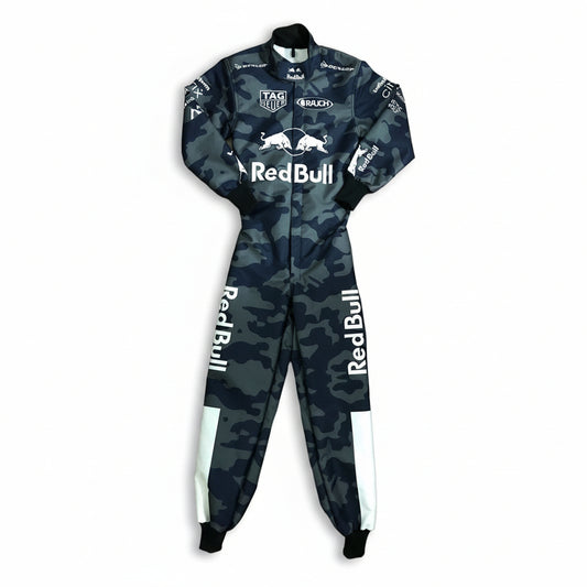 A full-body racing suit with a dark blue and gray camouflage pattern, featuring prominent white Red Bull logos on the chest and legs, and sponsor logos including TAG Heuer and Ruach on the sleeves and chest.
